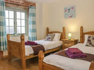 a bedroom with two twin beds and a window at Orchard Cottage in Newtown