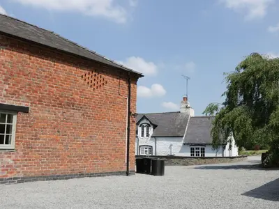 a red brick building next to a white house at Orchard Cottage in Newtown