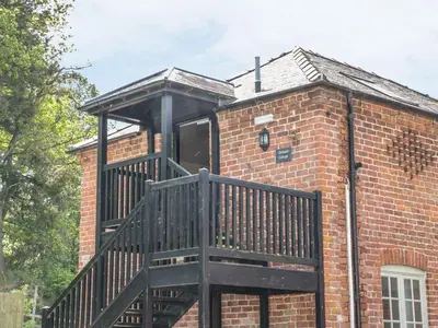 a small brick building with a balcony on it at Orchard Cottage in Newtown