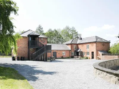 a brick building with a staircase in front of it at Woodside Cottage in Newtown