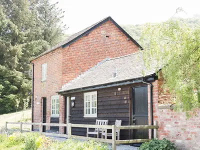 a brick house with two chairs in front of it at Ramblers in Newtown