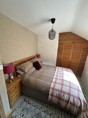 a bedroom with a large bed with a wooden headboard at Maengwynedd, Llanrhaeadr Ym Mochnant in Oswestry