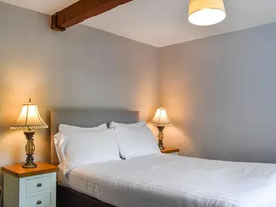 a bedroom with a bed and two lamps at Pengarreg Fawr- Uk47774 in Llanilar