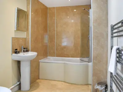 a bathroom with a tub and a sink and a shower at Pengarreg Fawr- Uk47774 in Llanilar