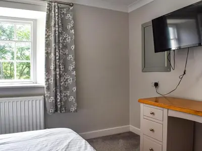 a bedroom with a bed and a window at Pengarreg Fawr- Uk47774 in Llanilar