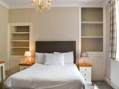 a bedroom with a white bed and two night stands at Pengarreg Fawr- Uk47774 in Llanilar