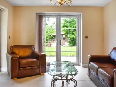 a living room with two chairs and a glass table at Haul Y Bore in Aberystwyth