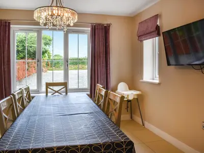a dining room with a long table and a large window at Haul Y Bore in Aberystwyth