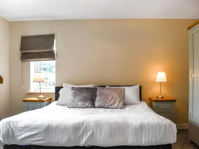 a bedroom with a white bed with two lamps at Haul Y Bore in Aberystwyth