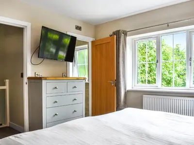a bedroom with a bed and a tv on the wall at Haul Y Bore in Aberystwyth