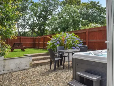 a backyard with a table and chairs and a tub at Cottage 1- Uk47770 in Llanilar