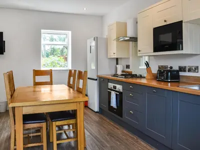 a kitchen with blue cabinets and a wooden table at Cottage 1- Uk47770 in Llanilar