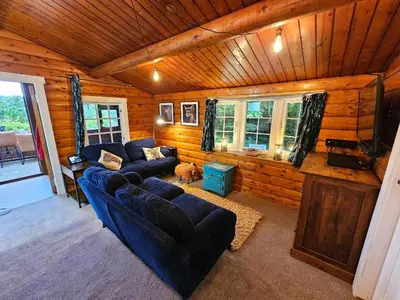 a living room with a blue couch and a tv at Bryn Cnocell in Trawsfynydd