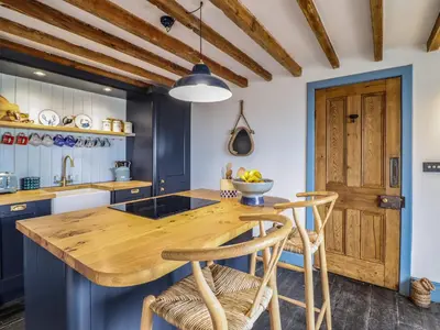 a kitchen with a wooden table and chairs at Pengarreg in Barmouth