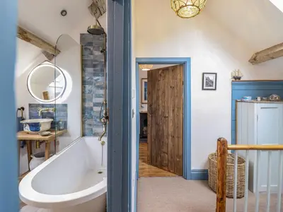 a bathroom with a tub and a sink at Pengarreg in Barmouth