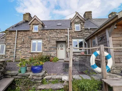 a stone house with a life preserver in front of it at Pengarreg in Barmouth