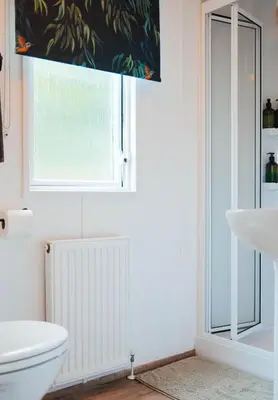 a bathroom with a white toilet and a window at Foxglove Lodge in New Quay