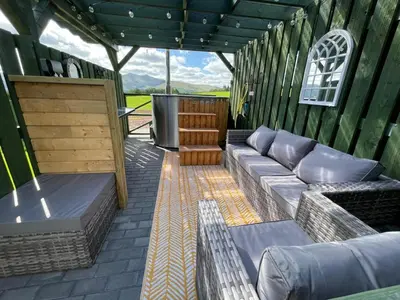 a covered patio with a couch and a table at Little Cottage of the Beacons in Brecon