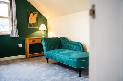 a green couch in a room with a table at Carreg Wen in Harlech