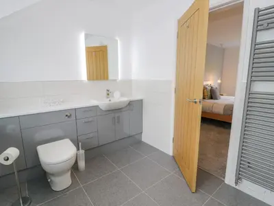 a bathroom with a toilet and a sink and a bed at Melin Y Plas in Barmouth