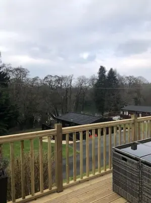 a wooden railing on a deck with a view of a yard at 5f Stanley Lodge, Caer Beris, Builth Wells - No tradesman in Builth Wells