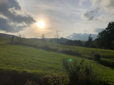 a green field with the sun in the sky at 5f Stanley Lodge, Caer Beris, Builth Wells - No tradesman in Builth Wells