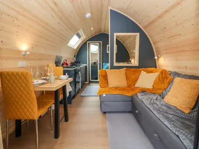 a living room and kitchen with a couch and a table at Heron Pod in Oswestry