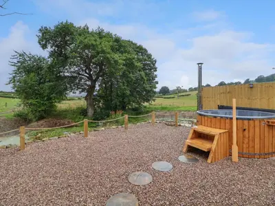 a pool in a yard with a wooden fence at Heron Pod in Oswestry