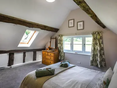 a bedroom with a bed and a window at Ty-Ucha Cottage in Llangollen