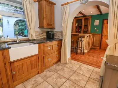 a kitchen with wooden cabinets and a sink at The Willows in Llangollen