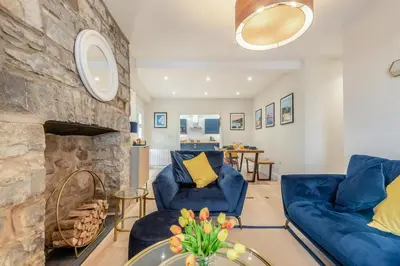 a living room with blue chairs and a stone fireplace at 3 Bed in New Quay oc-c29640 in New Quay