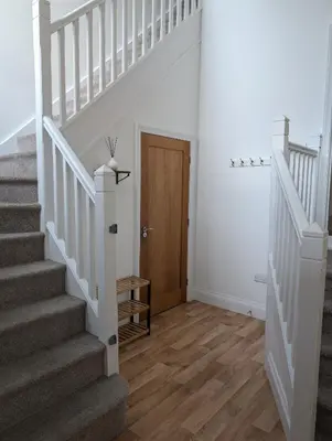 a staircase in a home with white walls and wooden floors at 2 Chapel Nazareth in Penrhyndeudreath