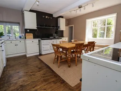 a kitchen with a wooden table and chairs in it at New Hall in Wrexham