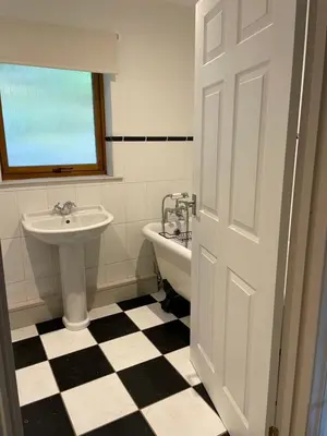 a black and white bathroom with a sink and a toilet at Llety Cynnes in Machynlleth