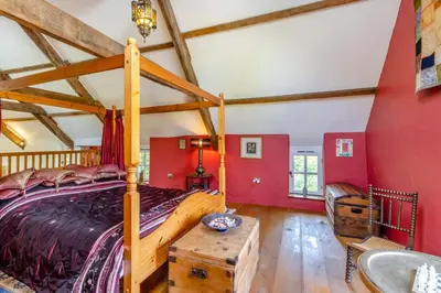 a bedroom with red walls and a bed and a tub at 1 Bed in Llwynygroes oc-y29714 in Llangeitho