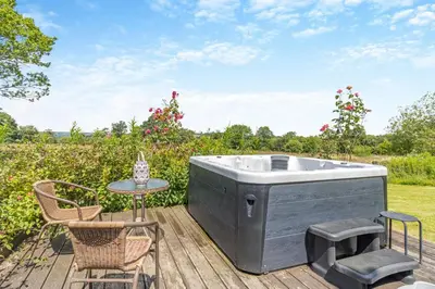 a hot tub on a deck with a table and chairs at 1 Bed in Llwynygroes oc-y29714 in Llangeitho