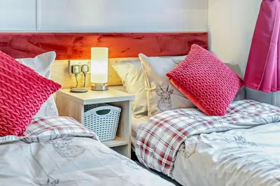 two beds in a bedroom with red and white pillows at 2 Bed in Gilfachrheda oc-o29754 in Llanina