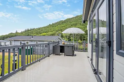 a balcony with a table and an umbrella at 2 Bed in Gilfachrheda oc-o29754 in Llanina