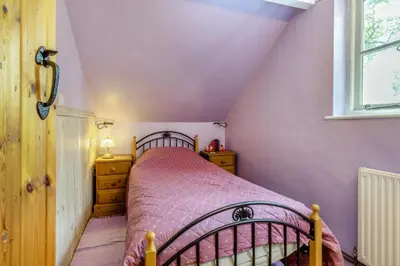 a small bedroom with a bed and a window at 4 Bed in Llwynygroes oc-y29715 in Llangeitho