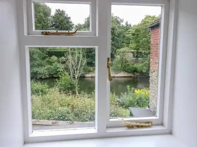 an open window with a view of a garden at Moorhen Cottage in Ludlow