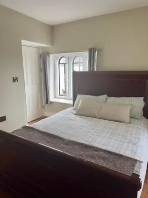 a large bed in a room with a window at Cross Hands Hotel in Llanybydder