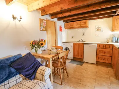 a kitchen and dining room with a table and a couch at Ty Bach Twt in Llandysul