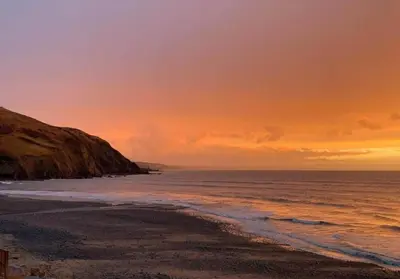 a view of a beach at sunset at Sea View Caravan - Aber Bay Holiday Park in Aberystwyth