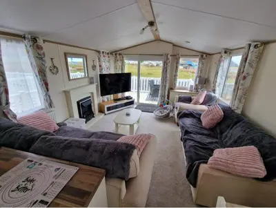 a living room with two couches and a television at Sea View Caravan - Aber Bay Holiday Park in Aberystwyth