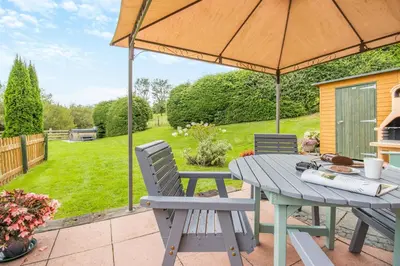 a picnic table with an umbrella on a patio at 2 Bed in Devils Bridge oc-d29575 in Devils Bridge