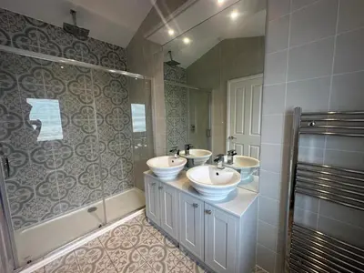 a bathroom with two sinks and a shower at WH - Smugglers Lodge in Aberaeron