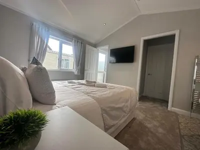 a bedroom with a white bed and a window at WH - Smugglers Lodge in Aberaeron