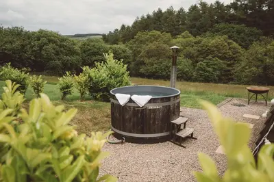 a large wooden barrel with a table and a bench at Brecon by Wigwam Holidays in Brecon