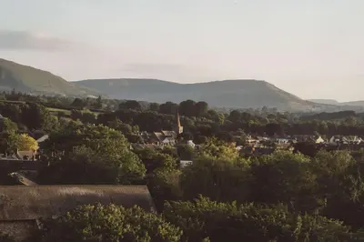a town with mountains in the background and trees at Brecon by Wigwam Holidays in Brecon