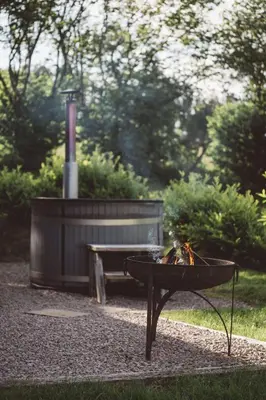 a fire pit and a bench in a park at Brecon by Wigwam Holidays in Brecon
